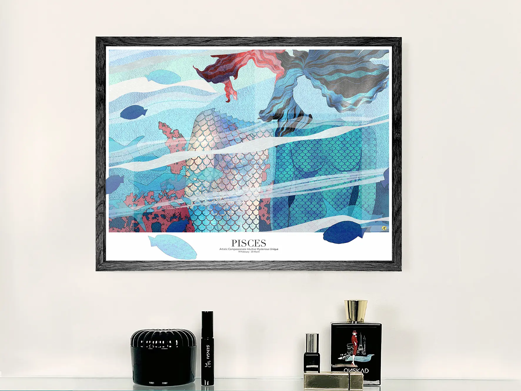 Framed artwork of the zodiac sign pisces. Below the picture on a glass shelf are some cosmetic items in black and gold. A small black glas bowl to the left and to the right is a perfume bottle with an illustrated label of a woman with Paris in the background. Off white colored wall.